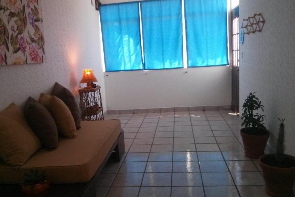 uma sala de estar com um sofá e uma janela em Casa cerca del centro de Morelia em Morelia