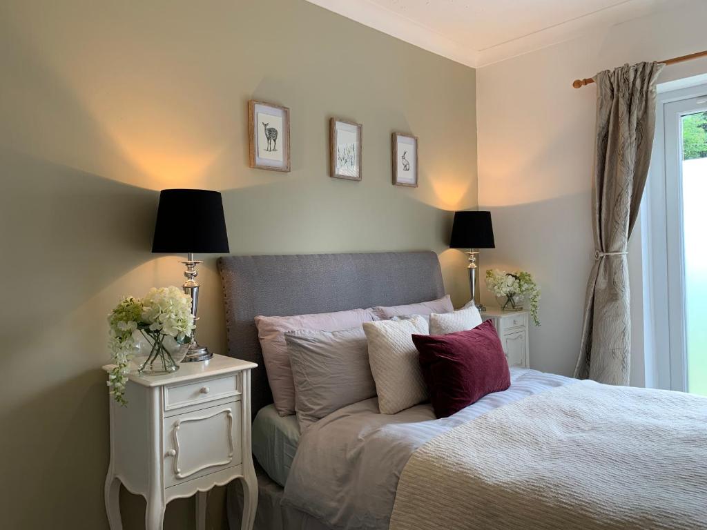 a bedroom with a bed and two lamps and a window at Thorn House in Fen Drayton