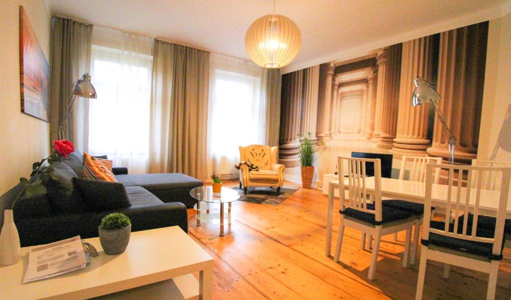 ein Wohnzimmer mit einem Sofa und einem Tisch in der Unterkunft Cozy Domicile Leipzig Center South in Leipzig