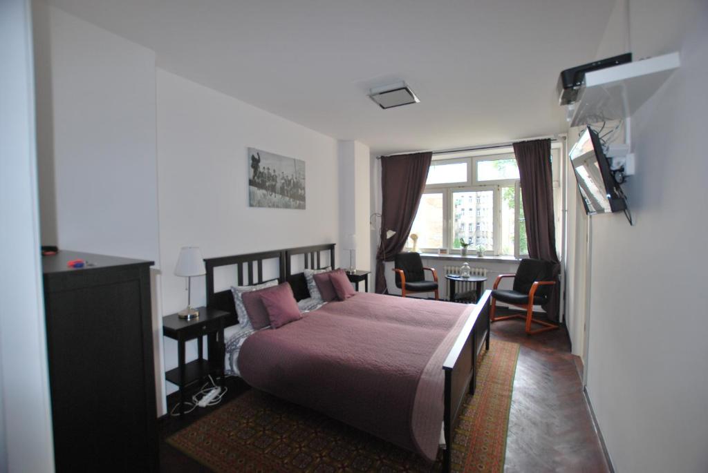 a bedroom with a bed with purple sheets and a window at Fiesta Apartament in Warsaw