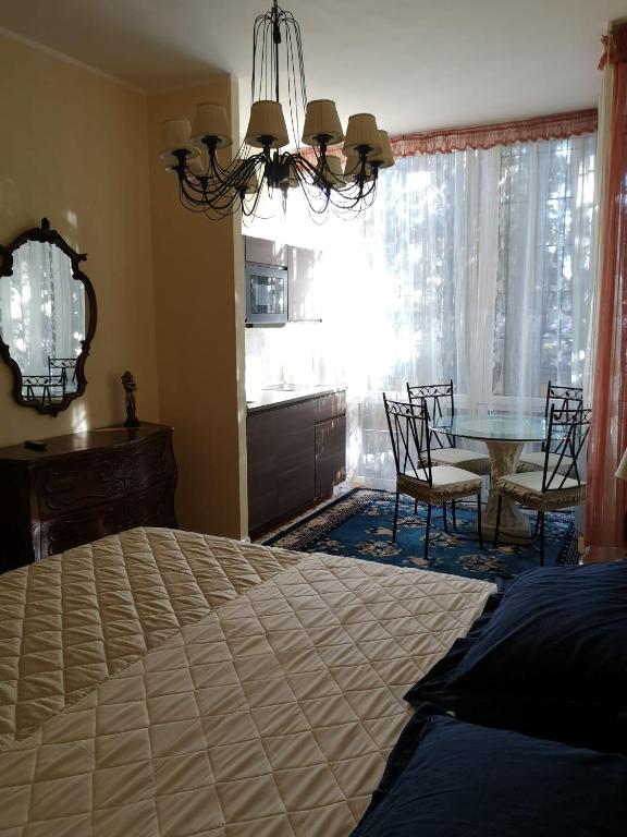 Schlafzimmer mit einem Bett und einem Tisch mit Stühlen in der Unterkunft AKIRE in Rom
