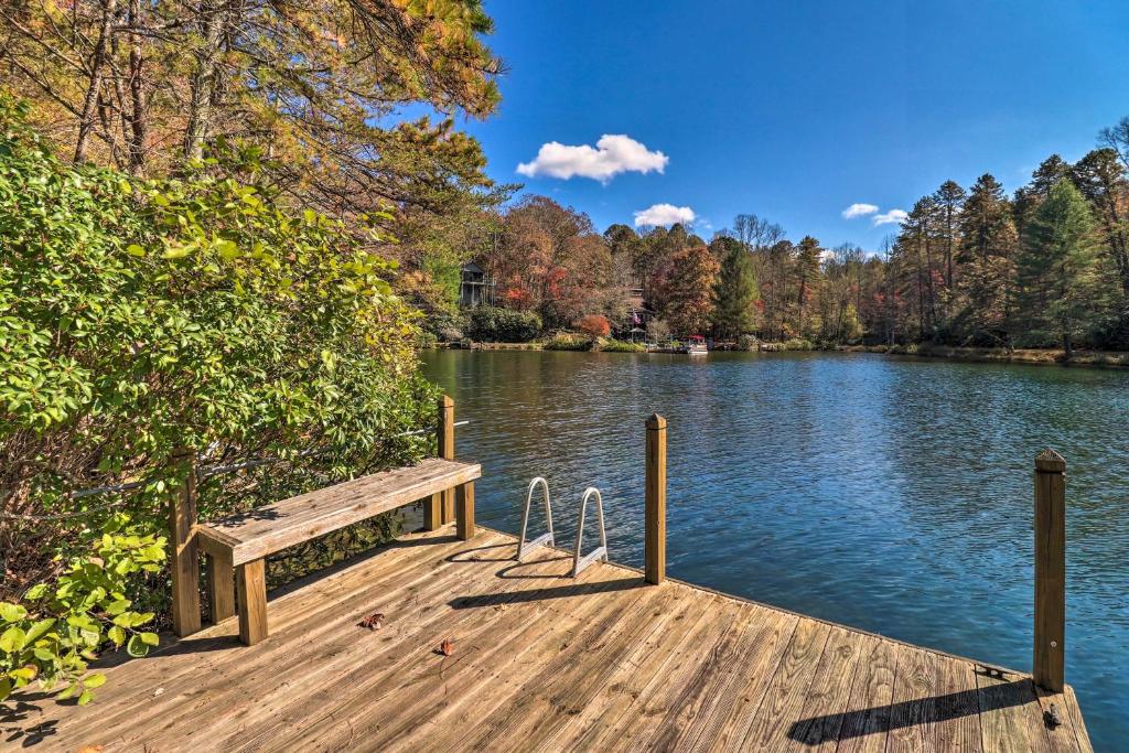 a wooden dock with a bench on a lake at Festive Lakefront Escape Blue Ridge Holiday Home in Brevard