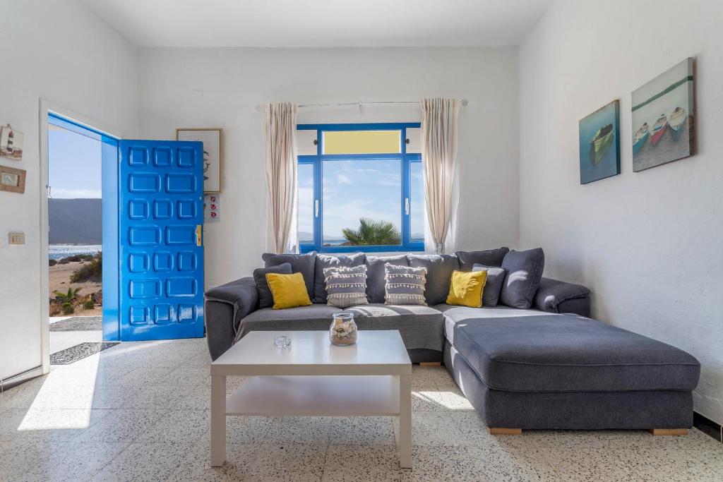 sala de estar con sofá azul y mesa en El Graciosero en Caleta de Sebo