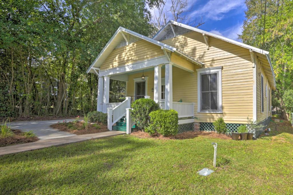 una pequeña casa amarilla con porche y patio en Thomasville Cottage Near The Big Oak and Downtown!, en Thomasville