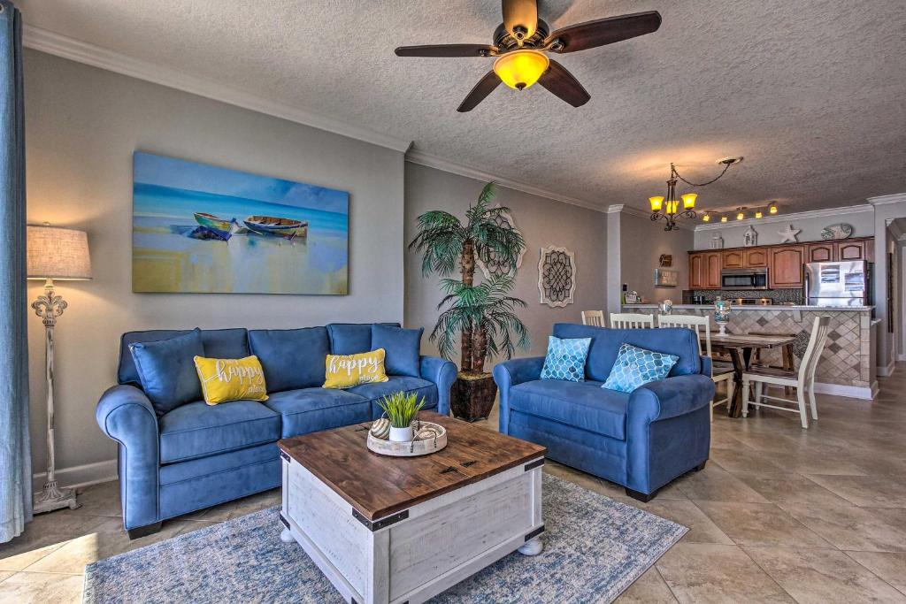 a living room with blue couches and a table at Beachfront PCB Condo with Ocean Views and Pool Access! in Panama City Beach
