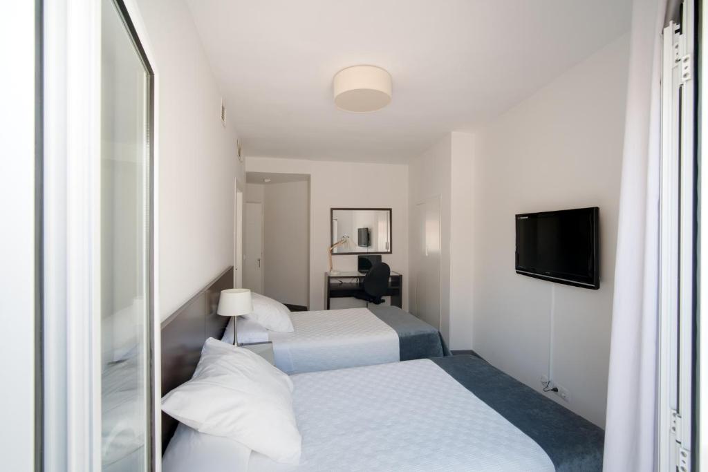 Postel nebo postele na pokoji v ubytování Hotel Madrid de Sevilla