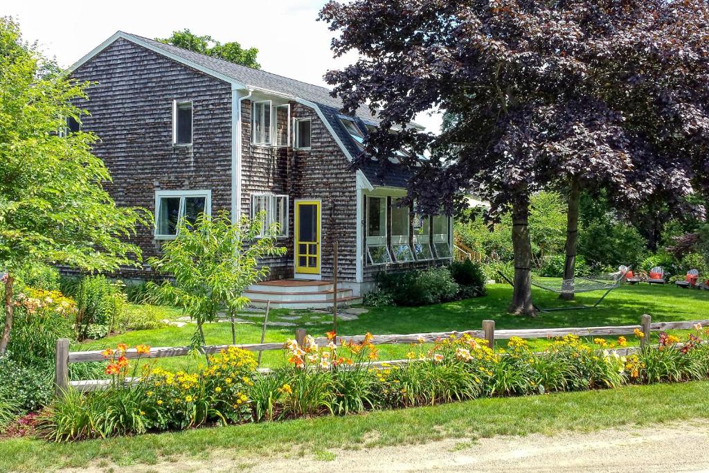 una casa con un jardín de flores delante de ella en Mermaid House, en Biddeford