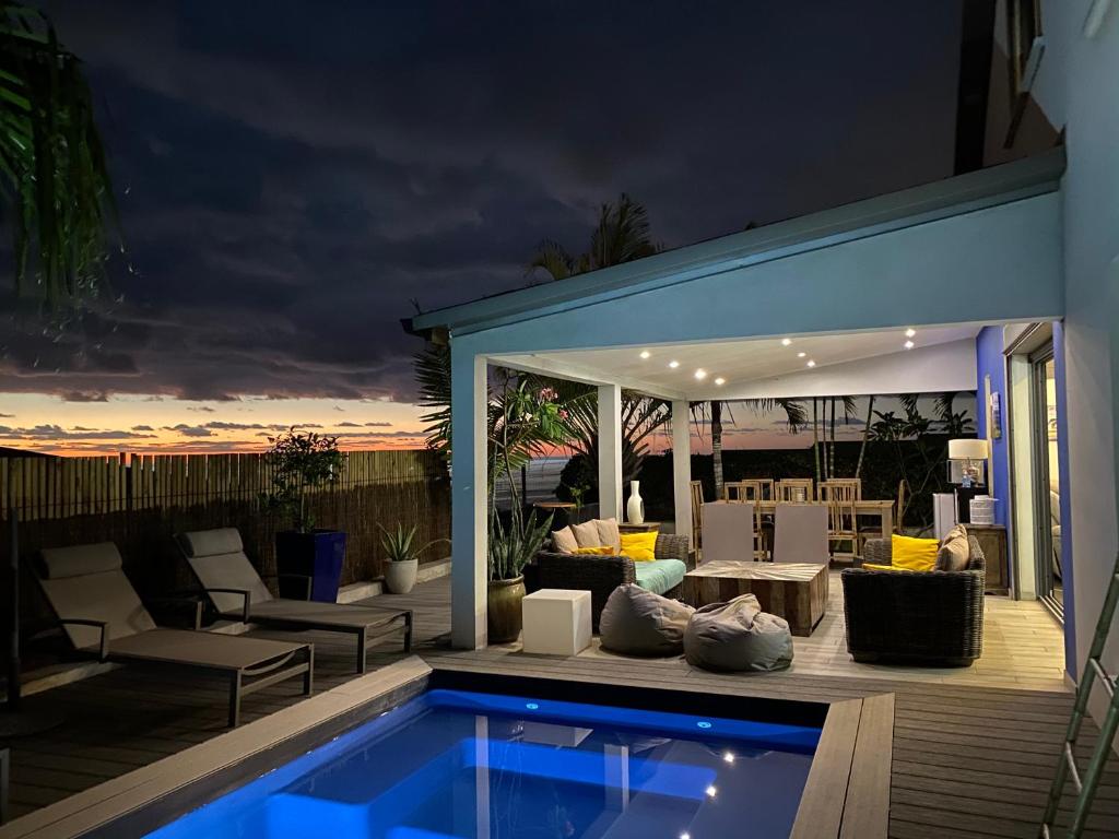 a patio with a swimming pool at night at Chambres d'hôtes CASA COSY in Les Avirons