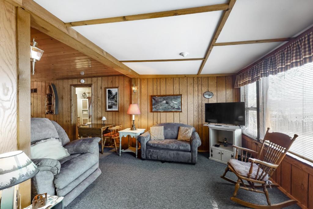 ein Wohnzimmer mit einem Sofa und einem TV in der Unterkunft Catfish Cottage A in Eagle River