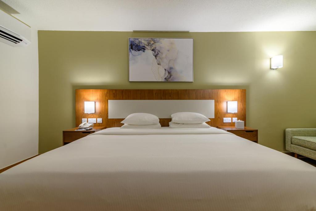 a bedroom with a large white bed with two pillows at Dhafra Beach Hotel in Jebel Dhanna