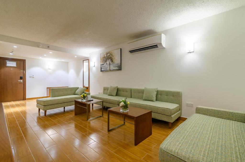 a living room with two couches and a table at Dhafra Beach Hotel in Jebel Dhanna