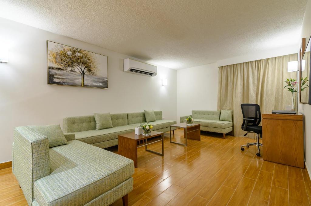 a living room with a couch and a table at Dhafra Beach Hotel in Jebel Dhanna