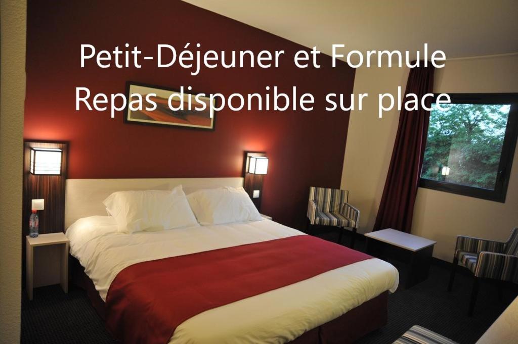 a bedroom with a large bed with a red wall at Hôtel AKENA La Ferté Bernard in Cherré