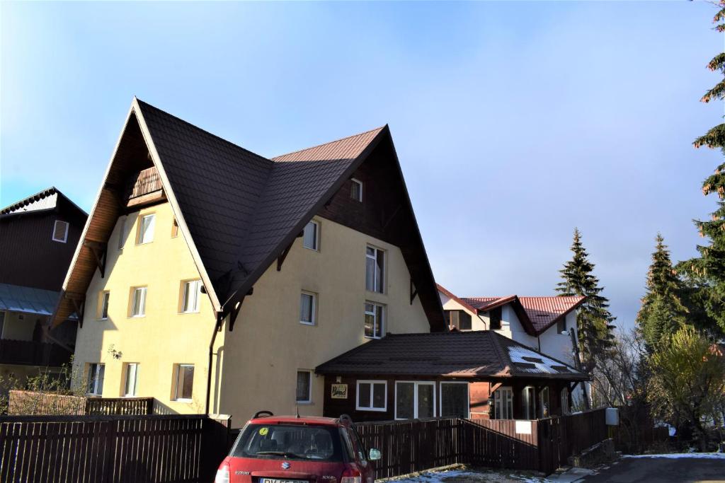 une grande maison avec un toit noir dans l'établissement Vila Brad, à Predeal