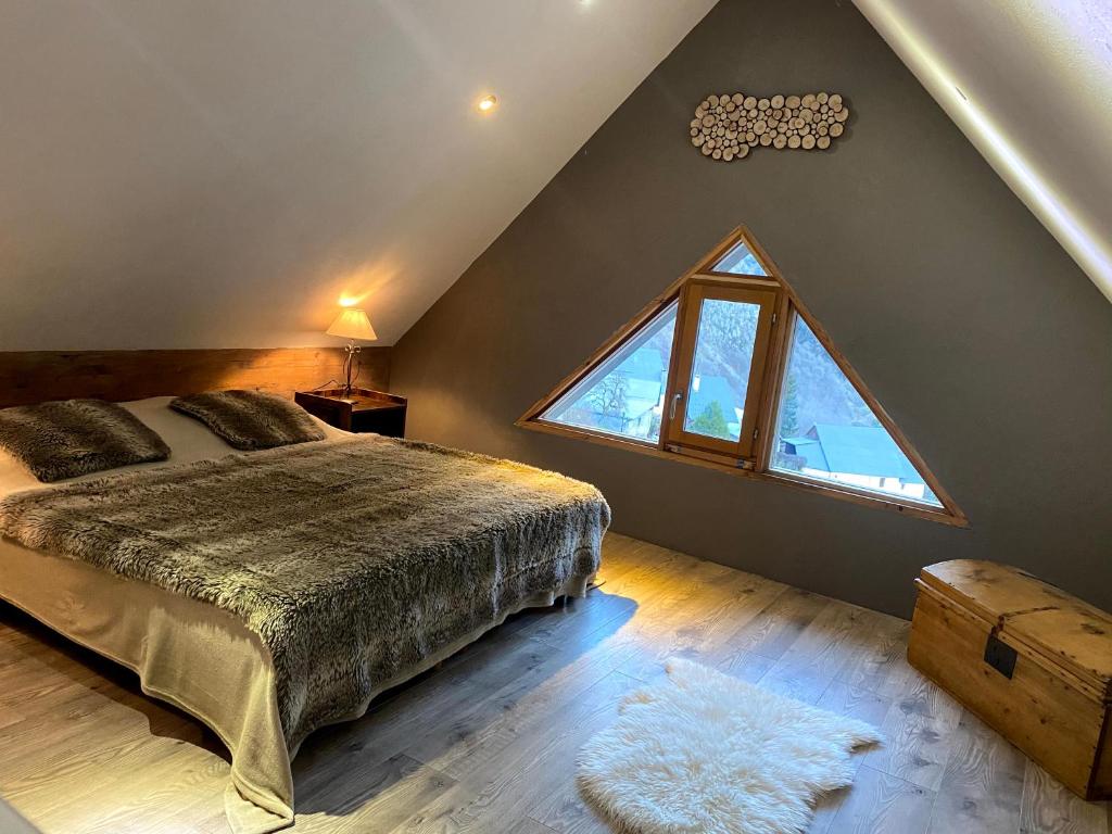 een slaapkamer met een bed en een groot raam bij VENOSC Le Haut de la Grange in Les Deux Alpes