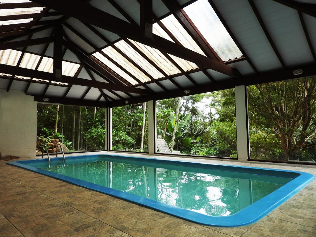 a swimming pool in a house with an open roof at Pousada do Pescador in Florianópolis