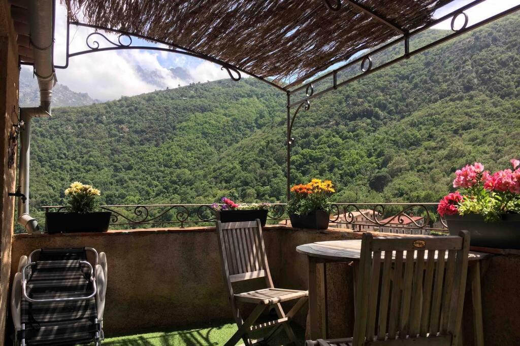 a balcony with a table and chairs and a view at Chez Marco Gîte & SPA U FILANCIU in Muro