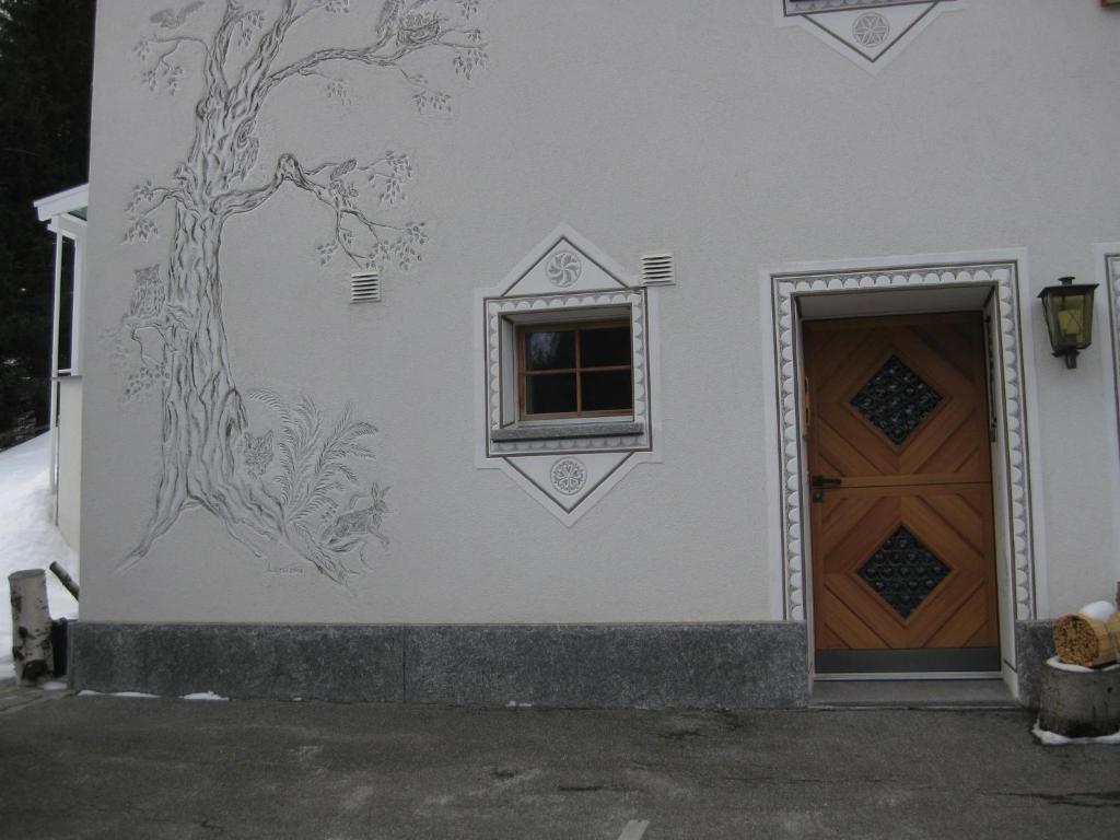 een schilderij aan de zijkant van een gebouw met een deur bij Casa Zupada/Wegmüller in Lenzerheide