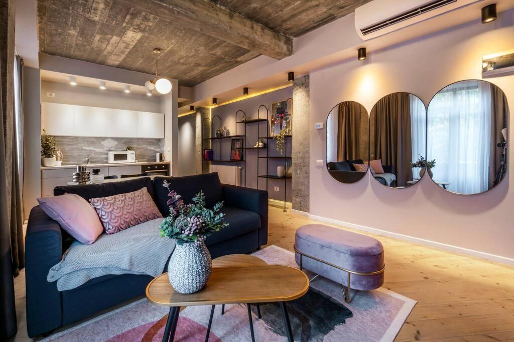 a living room with a couch and a table and mirrors at Marvellous Design 2Br Old Town in Bucharest