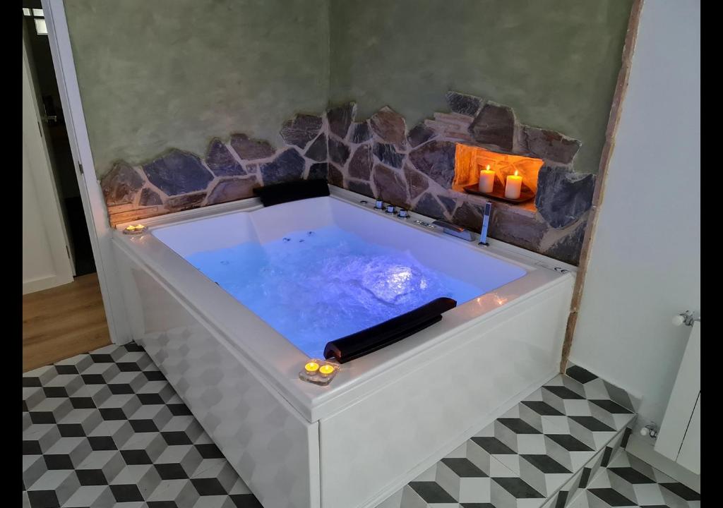 uma banheira de hidromassagem com lareira num quarto em Alojamientos Segóbriga Rural ( Mandil) em Segorbe