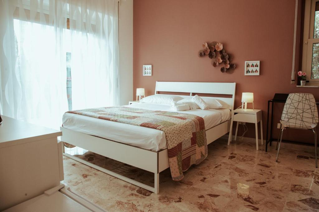 SoStanza - Rooms in Catania في كاتانيا: غرفة نوم بسرير ابيض ونافذة
