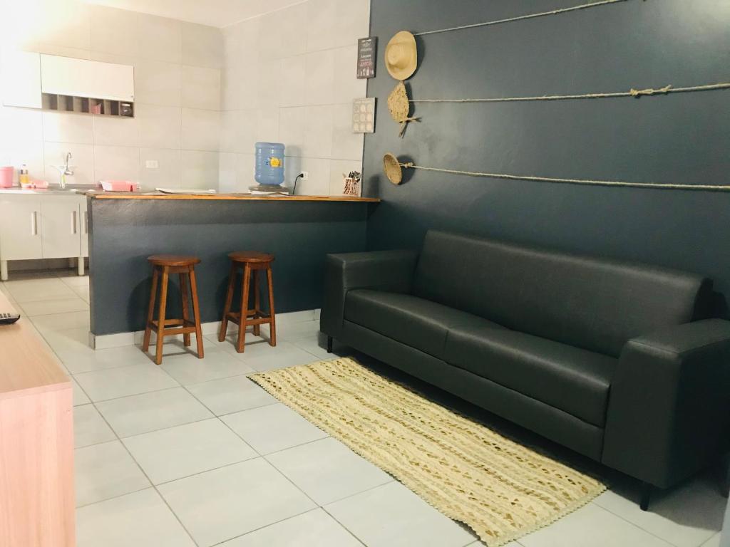 salon z zieloną kanapą i 2 stołkami w obiekcie Aconchego na Capital do Forró - Térreo w mieście Caruaru