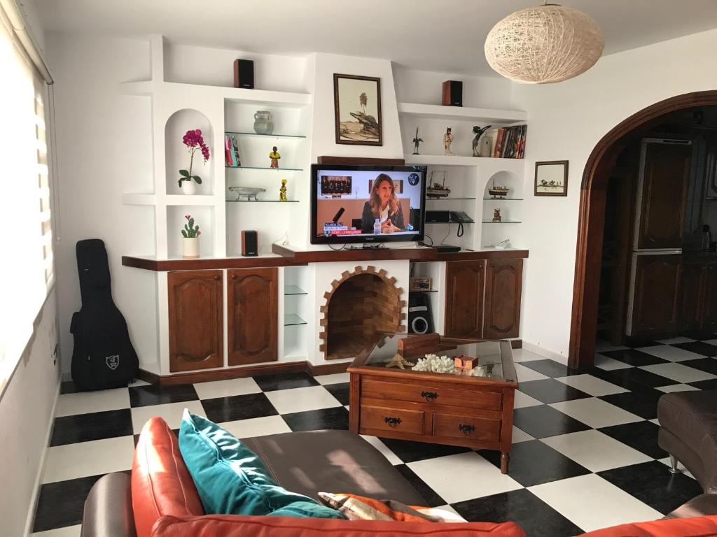 een woonkamer met een tv en een open haard bij Casa Galiano in Teguise