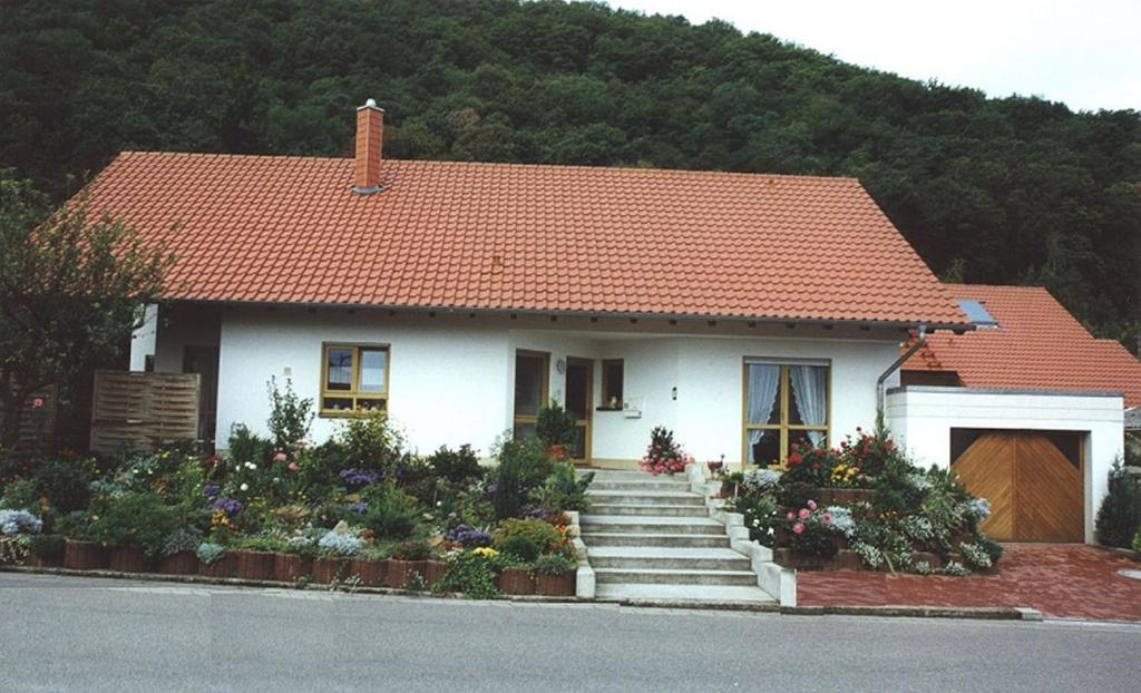 une petite maison blanche avec un toit orange dans l'établissement Haus am Fürstenweg, à Neustadt an der Weinstraße