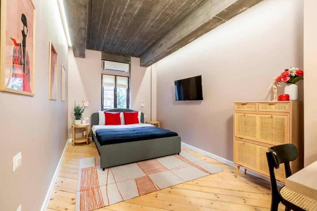 a bedroom with a bed and a tv on a wall at Marvellous Design Studio Old Town in Bucharest