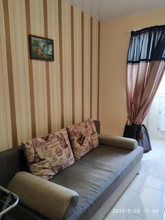 a couch in a living room with a striped wall at Алексеевские акварели.. in Kharkiv