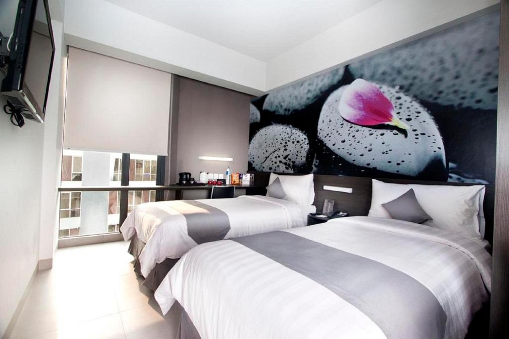 Postel nebo postele na pokoji v ubytování Neo Hotel Tendean Jakarta by ASTON