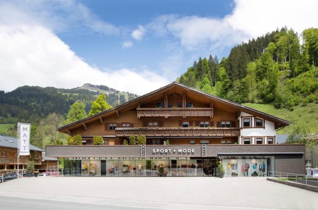 a large building with a mountain in the background at Pension Matt in Schoppernau