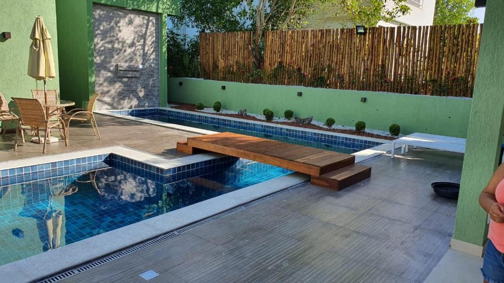 a swimming pool with a bench in the middle of it at Casa 6 Suítes - Praia de Itacimirim - Alto Padrão in Camaçari