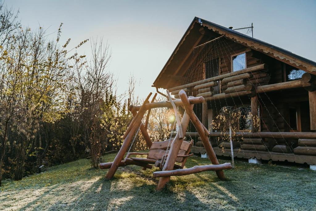 um parque infantil em frente a uma cabana de madeira em Väikesaare Guest House em Narva