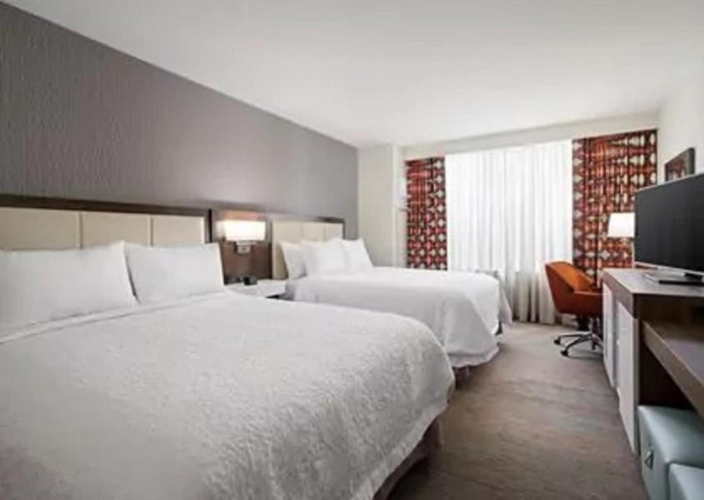 Glendale的住宿－Hampton Inn Glendale Milwaukee, Wi，酒店客房设有两张床和一台平面电视。