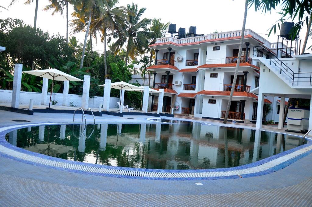 a swimming pool in front of a building at Nikhil Residence in Varkala