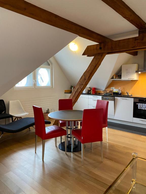 una cucina e una sala da pranzo con tavolo e sedie rosse di ZüriZimmer a Zurigo