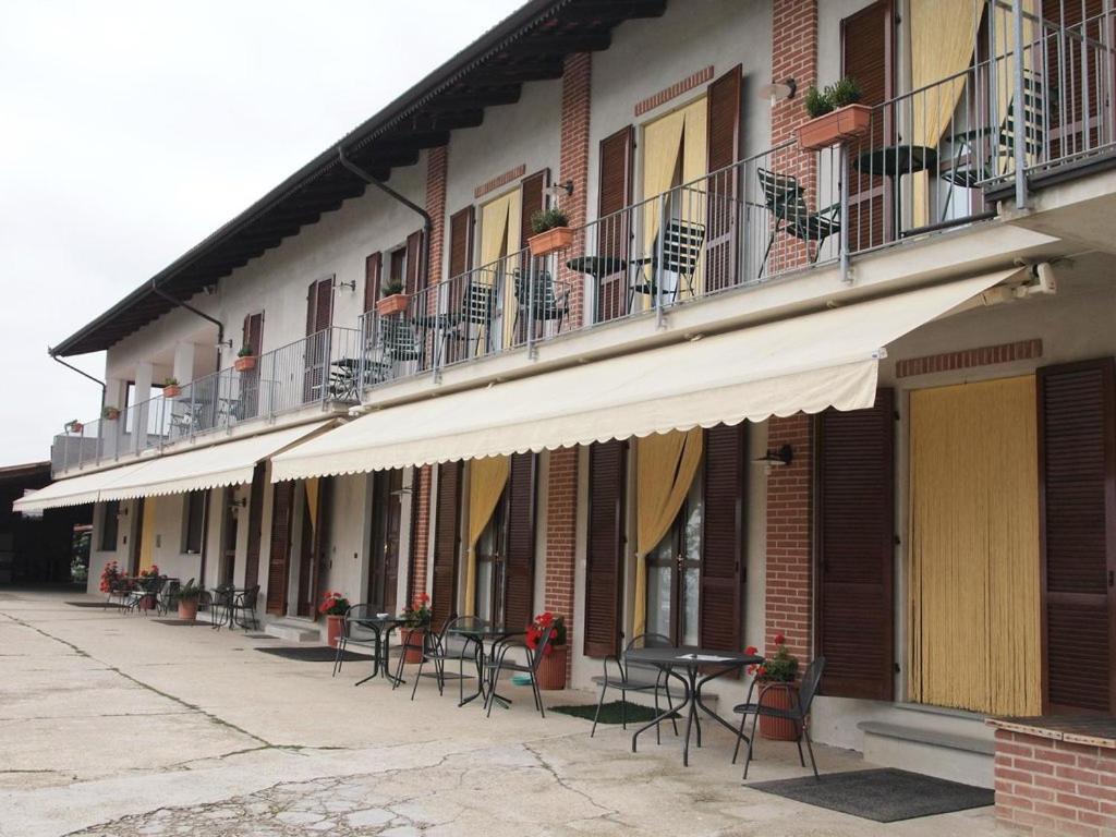 un grupo de mesas y sillas frente a un edificio en Agriturismo Le Viole, en Barolo