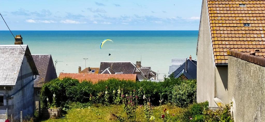 a kite flying in the sky over the ocean at Le clapotis de l'Ô, calme, balcon sur la mer, à 2 h de Paris in Ault