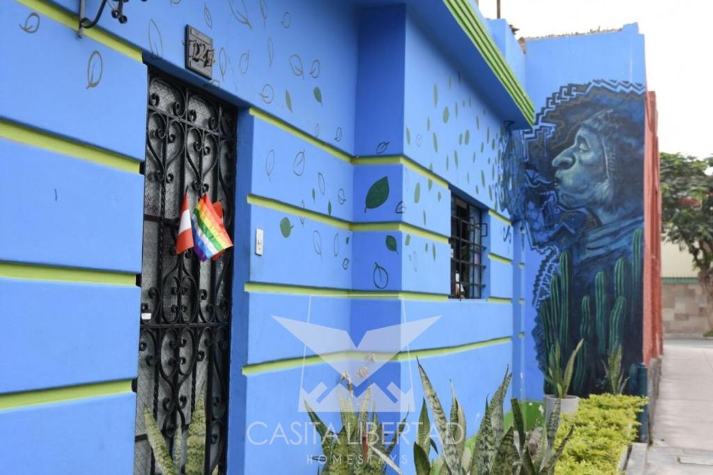 un edificio azul con graffiti en Casita Libertad Barranco, en Lima