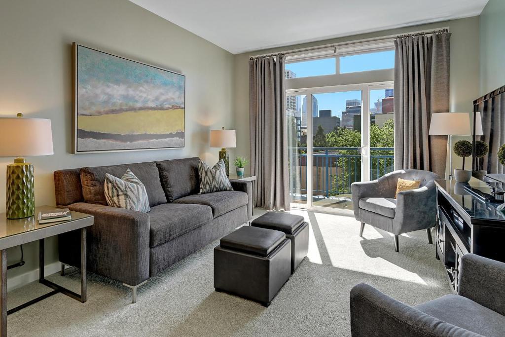 uma sala de estar com um sofá e uma televisão em City Water View Oasis with Pool & Gym near Cruise in Heart of Seattle em Seattle