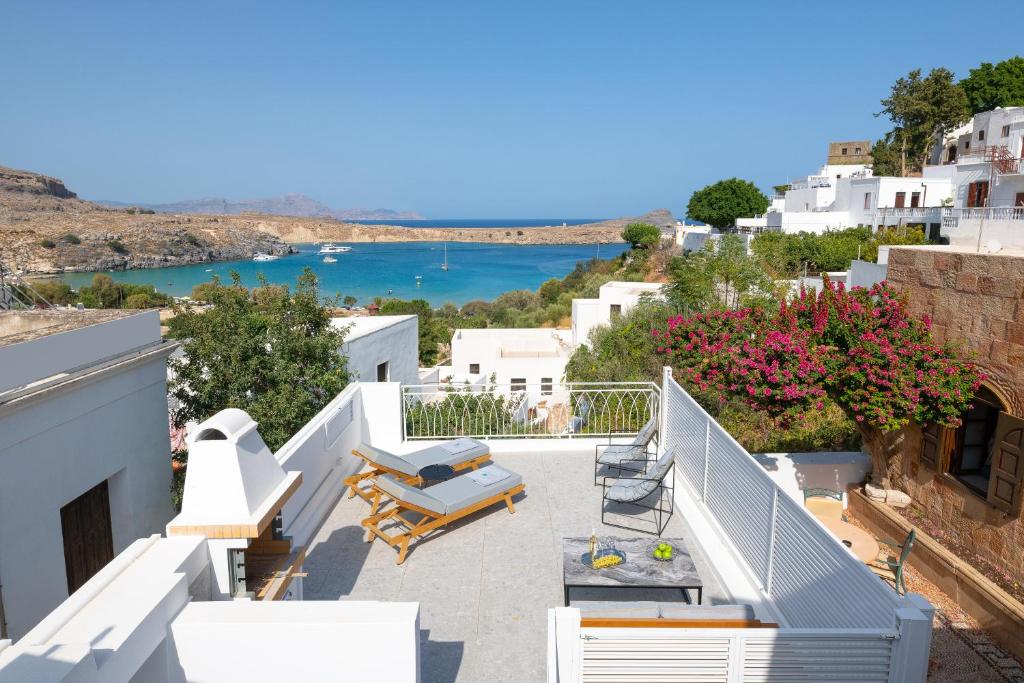 a balcony with chairs and a view of the water at Lindos Shore Junior Suite in Líndos