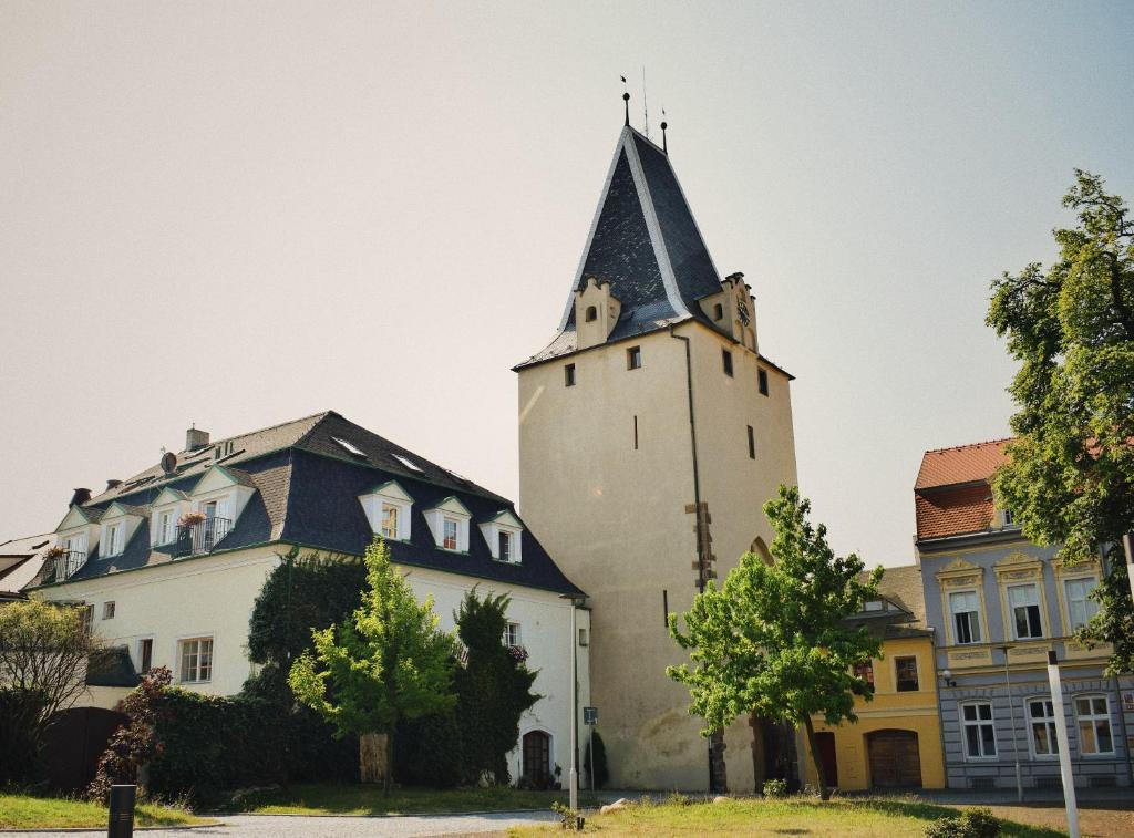 een gebouw met een toren en een huis bij Penzion U Johanky in Kadaň