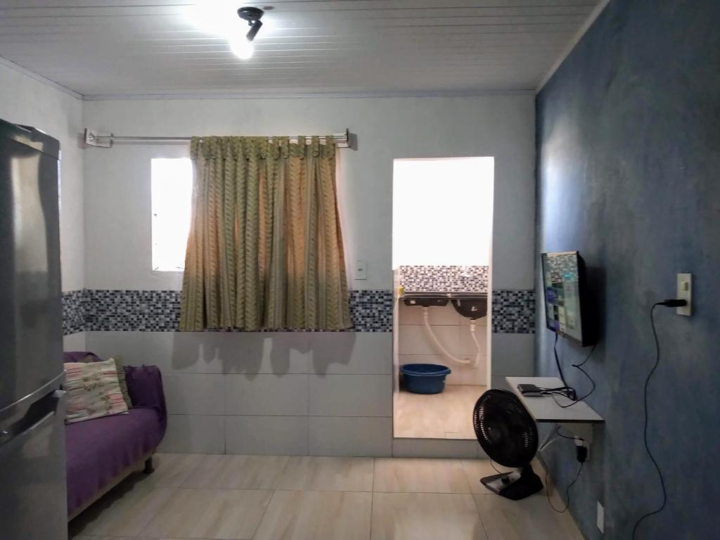 um pequeno quarto com um sofá roxo e uma janela em Quarto.sala topázio em Maceió