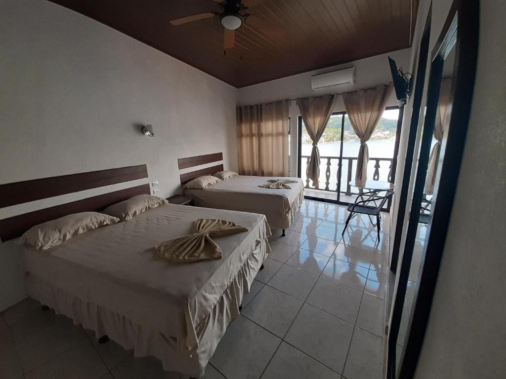 a hotel room with two beds and a balcony at La Posada De Don Jose in Flores