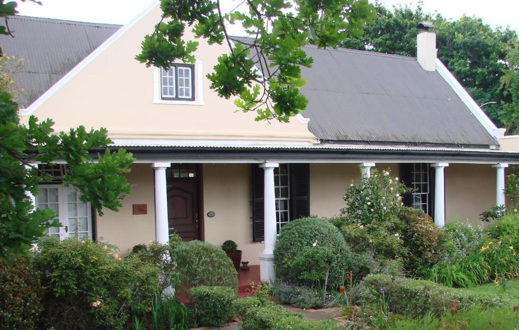 a white house with a black roof at Die Waenhuis Guest House in George