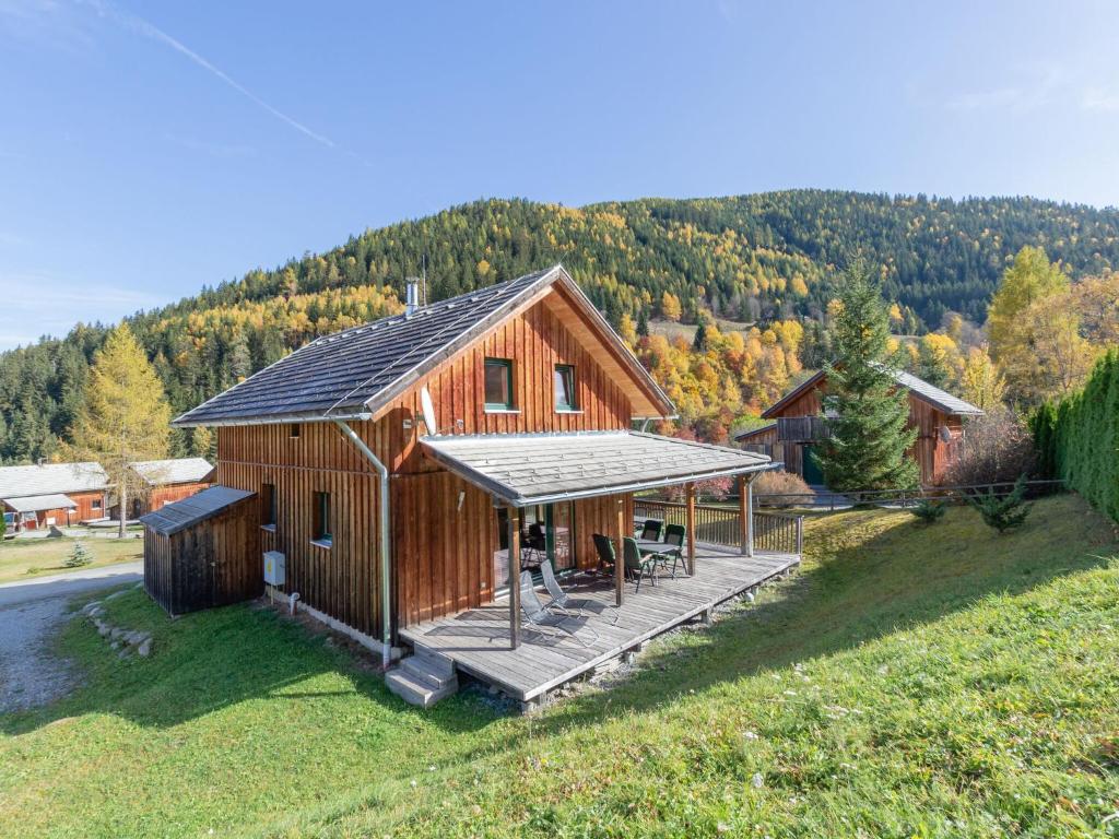 a large wooden cabin with a porch and a deck at Wooden chalet in Stadl an der Mur with sauna in Stadl an der Mur