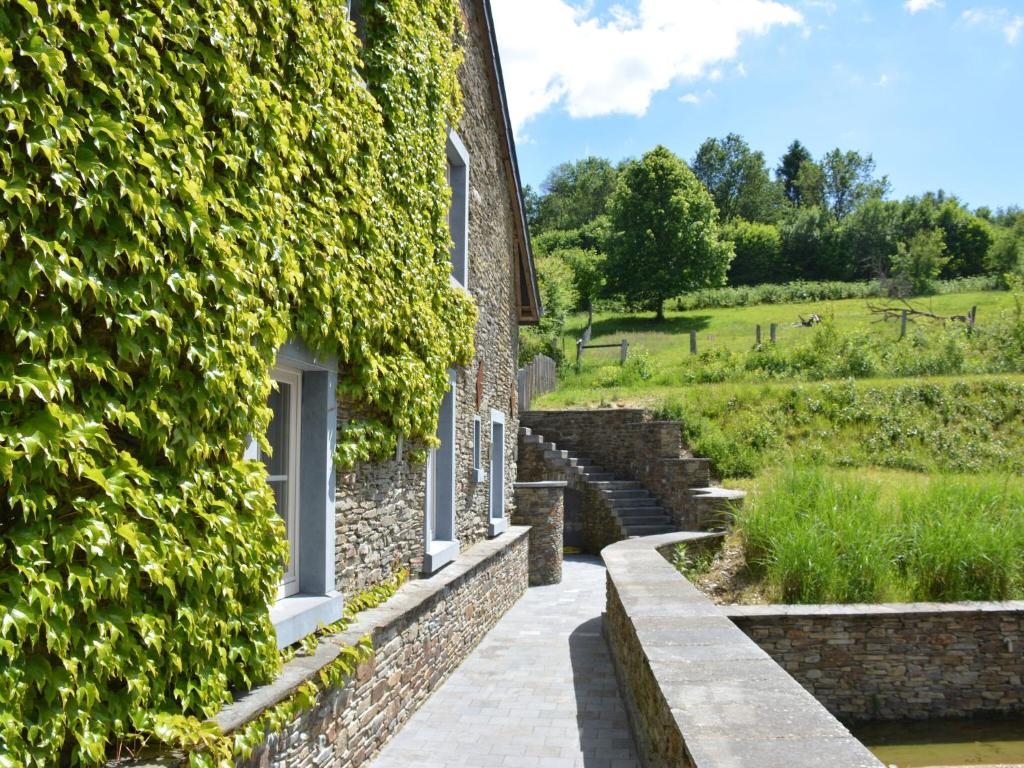 a building with ivy on the side of it at Villa with hottub in calm area in Bièvre