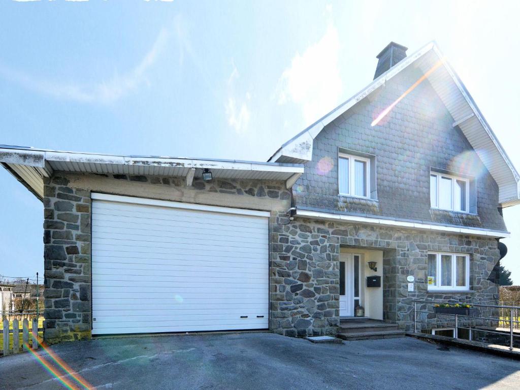 uma casa com duas portas de garagem numa garagem em Traditional Holiday home in B tgenbach with Sauna em Bütgenbach