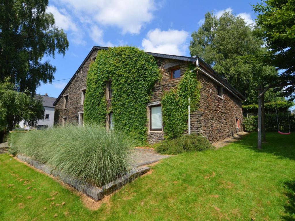 an ivy covered brick house with a yard at Wonderful Holiday Home in Noirefontaine in Bouillon